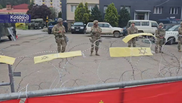 Žuta traka na bodljikavoj žici ispred pripadnika Kfora