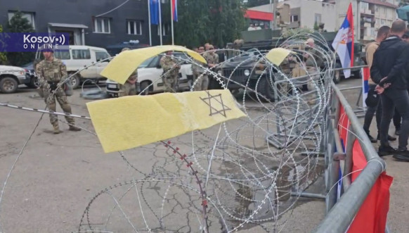 Žuta traka na bodljikavoj žici ispred pripadnika Kfora