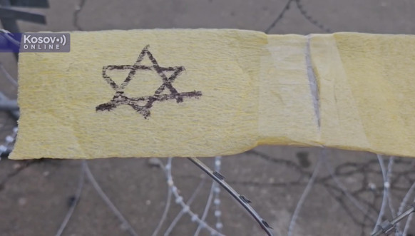 Žuta traka na bodljikavoj žici ispred pripadnika Kfora